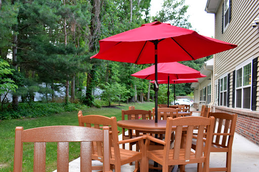A cozy outdoor seating area featuring wooden furniture and bright red umbrellas.