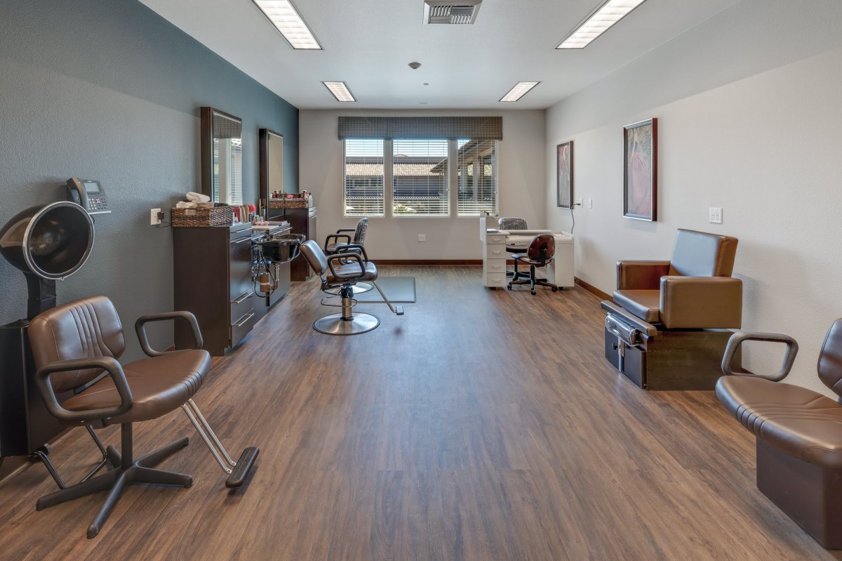 An empty hair salon with multiple workstations and mirrors.