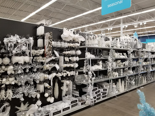 A well-organized aisle filled with various white holiday decorations.