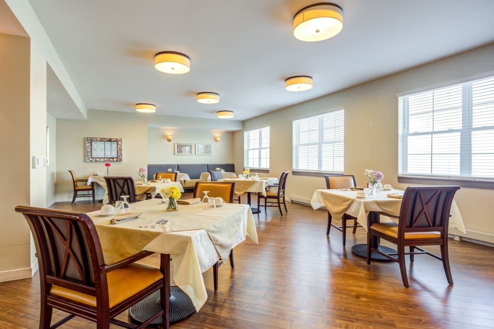 A well-lit dining area with neatly arranged tables and chairs.