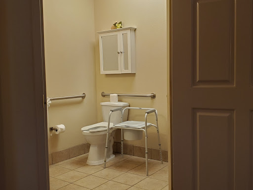 A view of a clean, accessible bathroom featuring a toilet and support bars.