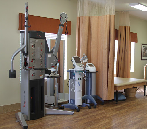 A well-equipped physical therapy room featuring various exercise machines and equipment for rehabilitation.