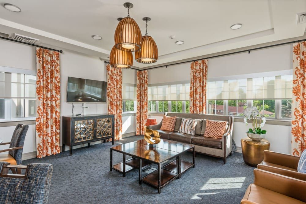 A stylish living room featuring a modern sofa, glass coffee table, and pendant lighting.