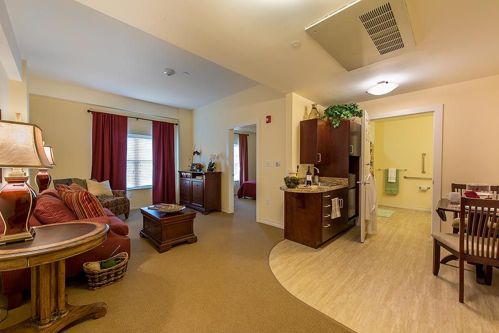 A cozy living space featuring a small kitchenette, comfortable seating, and warm decor.