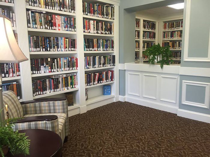 A cozy library corner with bookshelves filled with books and a comfortable chair.
