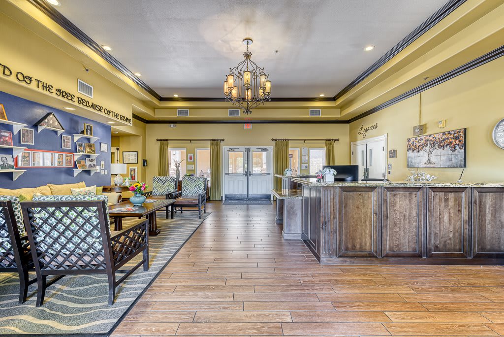 A welcoming lobby with a reception desk, seating area, and elegant chandelier.