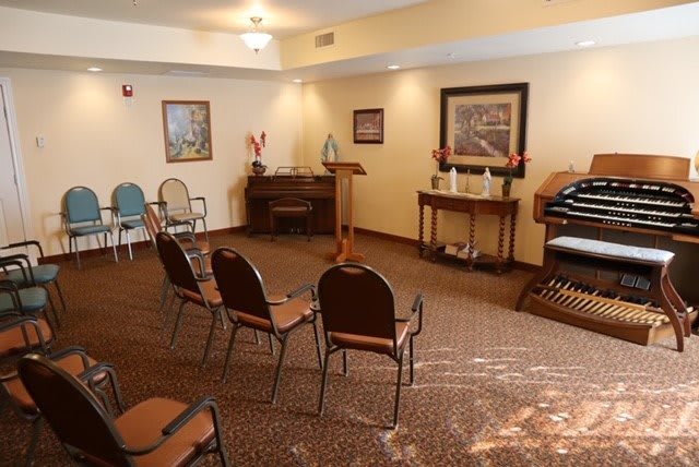 A cozy room with arranged chairs, a piano, and an organ.