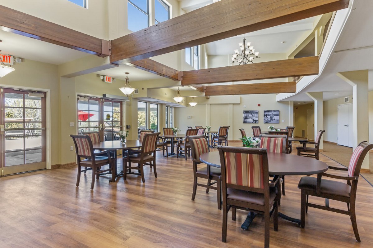 A spacious dining area with wooden beams and elegant chandeliers.
