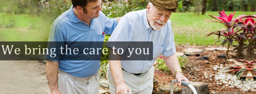 A caregiver assisting an elderly man outdoors.