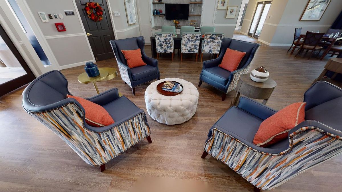 A cozy living room setup with four blue and patterned chairs arranged around a round coffee table.