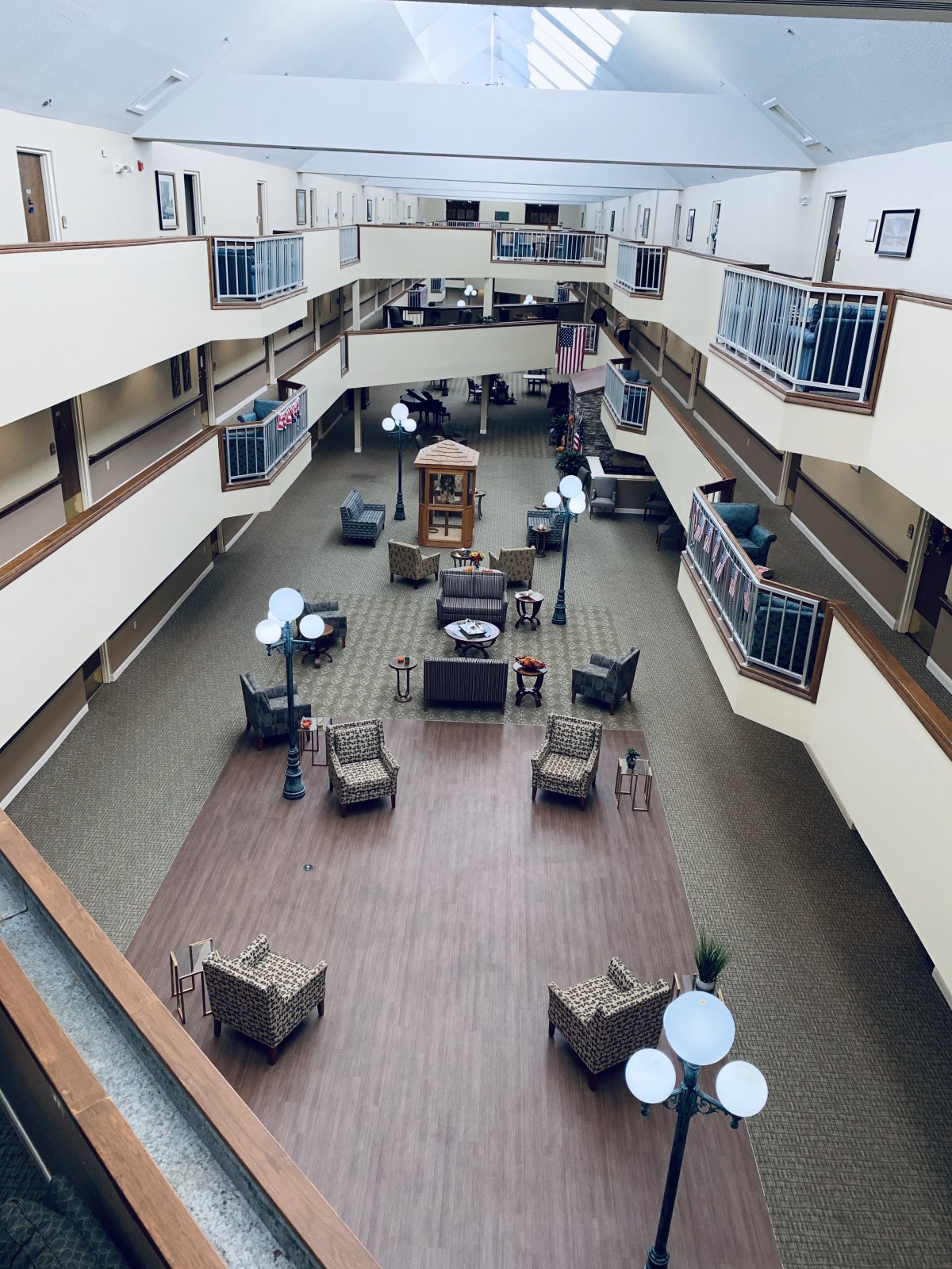 An interior view of a multi-story atrium with seating and lighting arrangements.