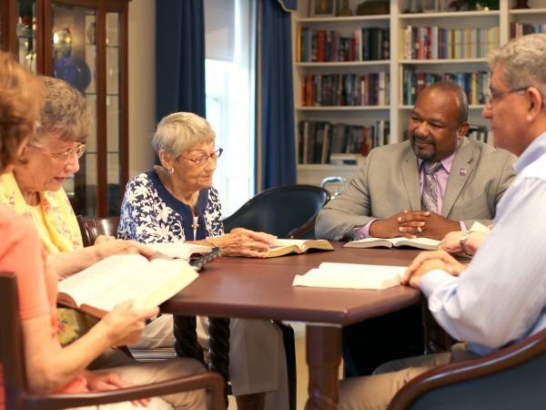 A group of people engaged in a book discussion at a library.