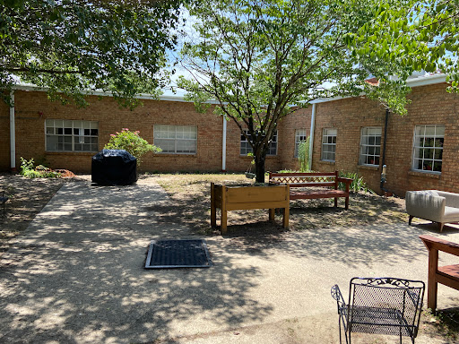 A peaceful courtyard with benches and trees providing shade.