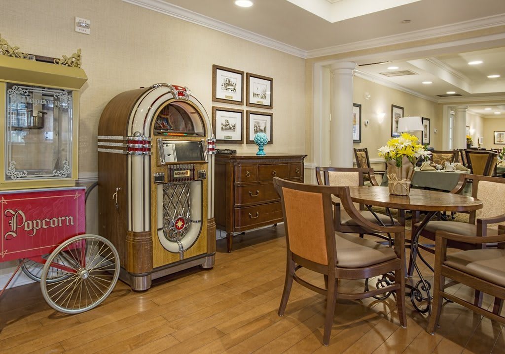A cozy dining area featuring a vintage jukebox and classic furniture on a wooden floor.