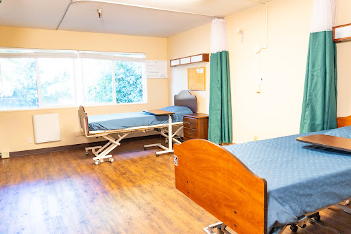 A view of a hospital patient room with two beds, showcasing a clean and well-lit environment.