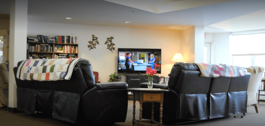 A cozy living room with recliner chairs facing a television.
