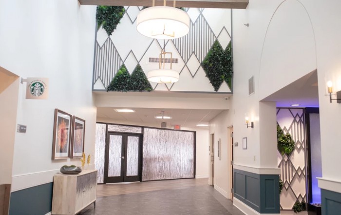 A modern lobby with geometric wall patterns and greenery accents.