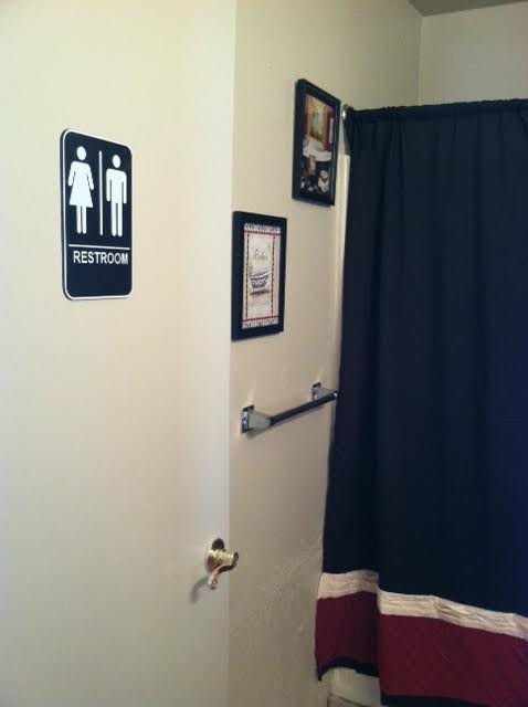 A restroom with a sign on the door and a curtain inside.