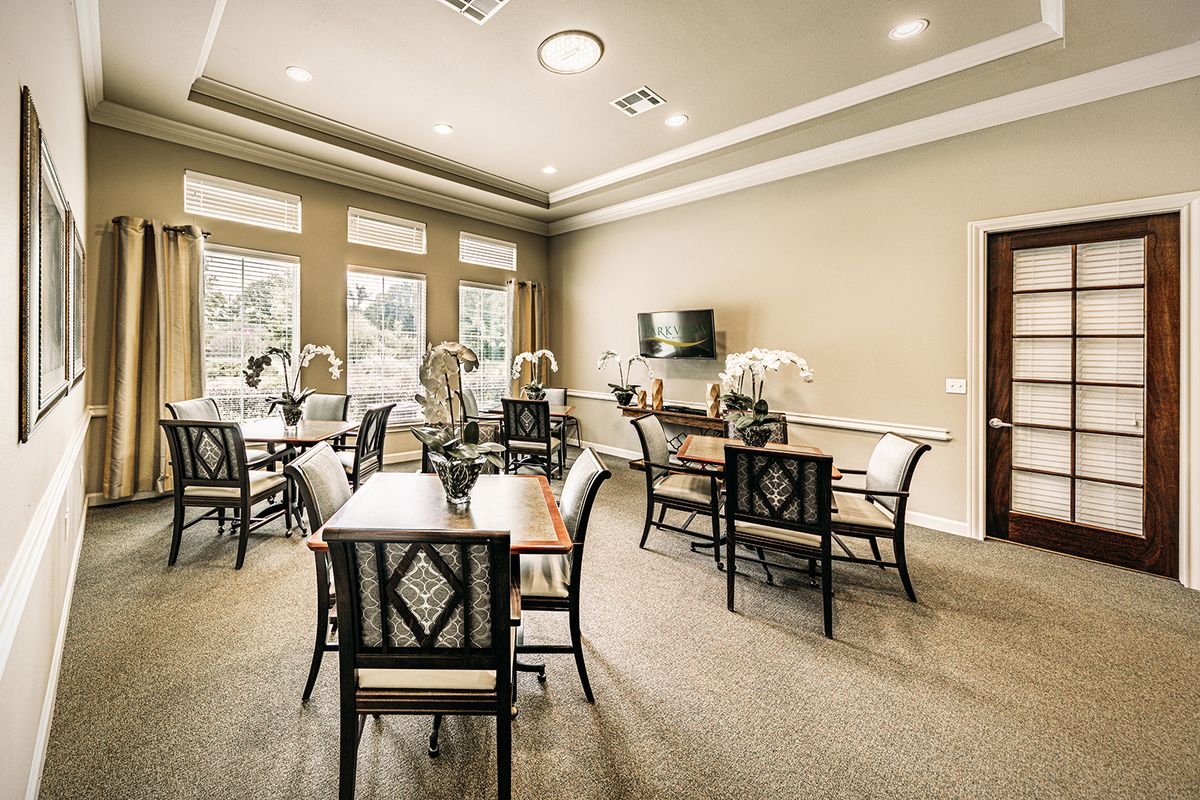 A modern dining area with neatly arranged tables and chairs, adorned with neutral decor and ample natural light.