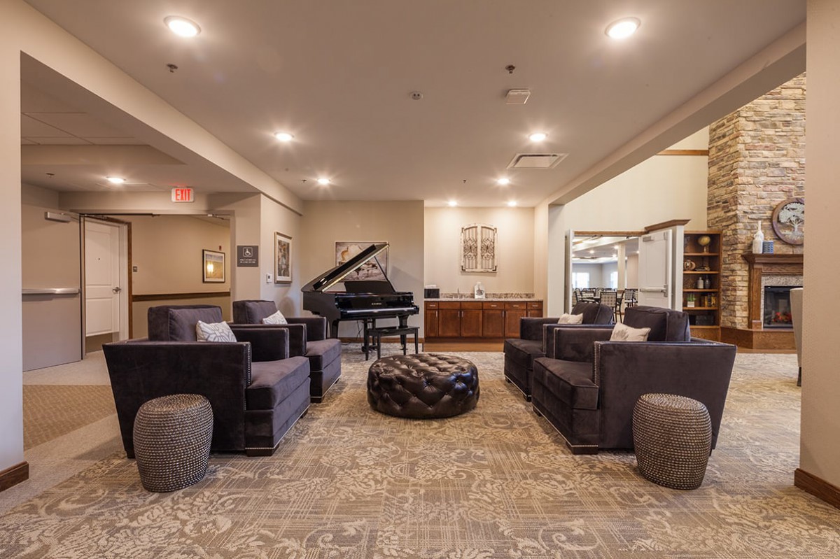 A modern lounge area featuring a grand piano and comfortable seating.