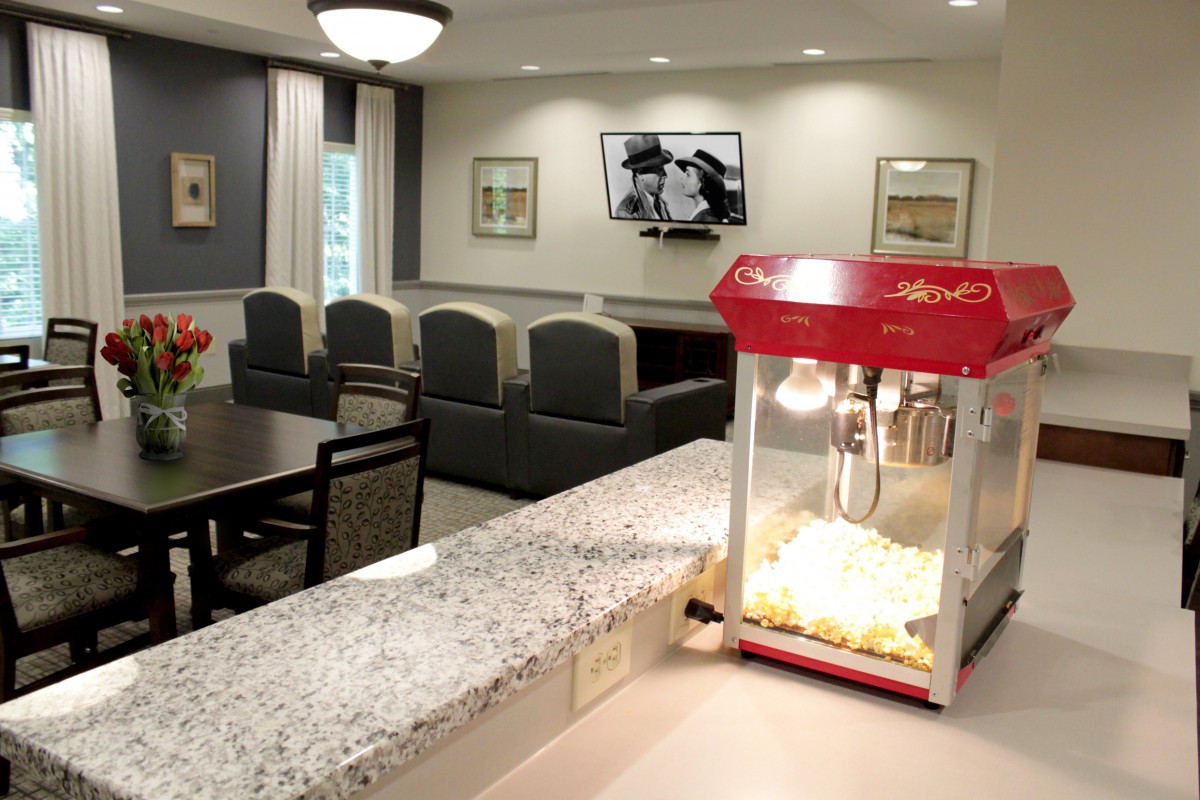 A cozy living room setup with a popcorn machine on the kitchen counter.