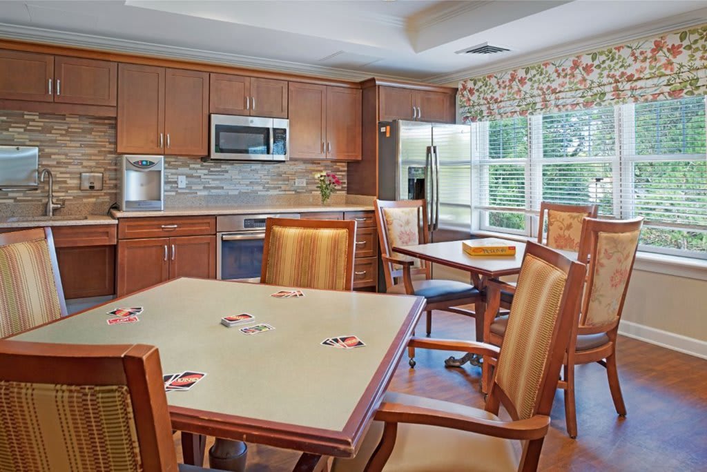 A cozy kitchen and dining area with wooden cabinets, a table, and chairs.