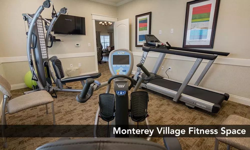 A well-equipped fitness center featuring a treadmill and exercise machines.