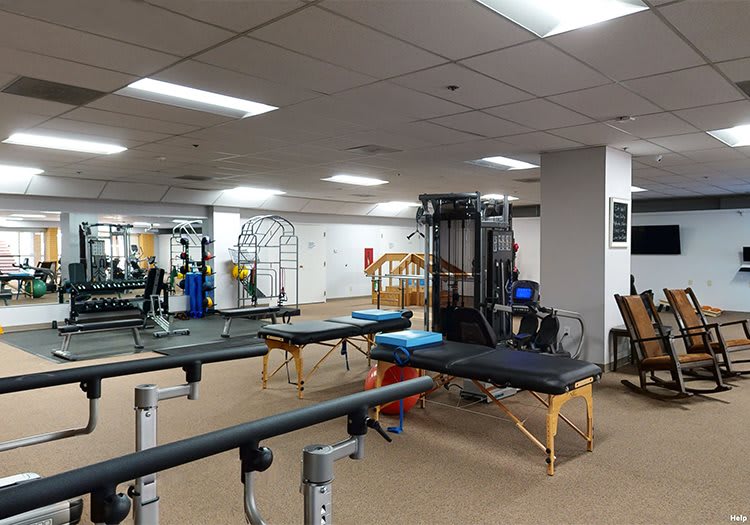 An indoor gym with various exercise equipment, including training benches and machines.