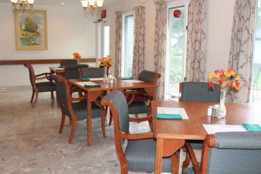 A cozy dining area with neatly arranged tables and chairs, featuring elegant decor.