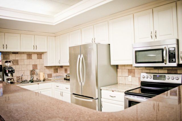 A modern kitchen with stainless steel appliances and white cabinetry.