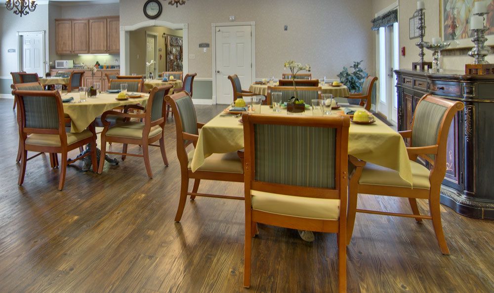 A neatly arranged dining room with tables and chairs set for meals.