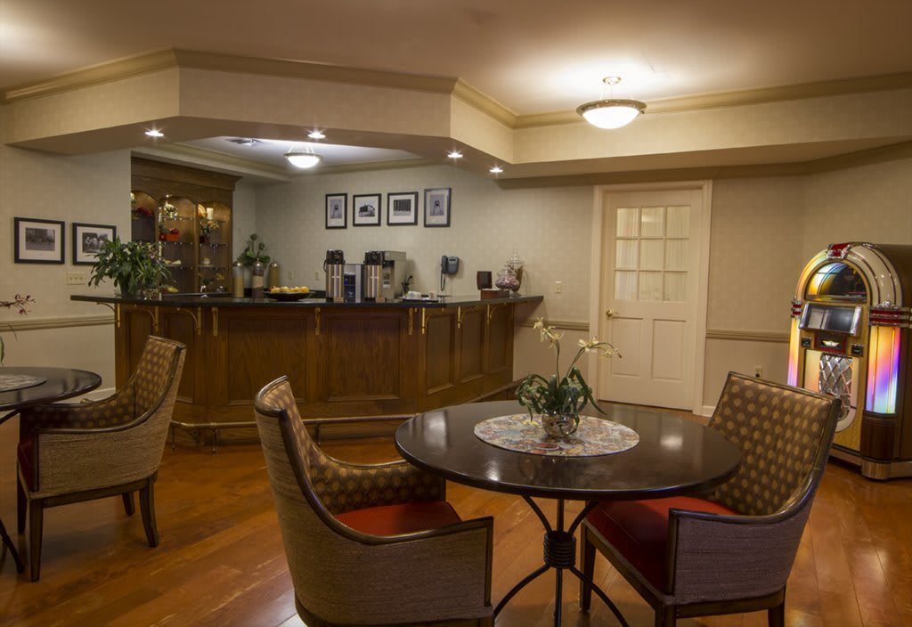 A cozy reception area with a wooden table, chairs, and warm lighting.