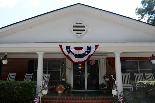 A charming house adorned with patriotic red, white, and blue bunting on the front porch.