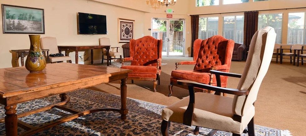 A cozy living room with red upholstered chairs and a patterned carpet.