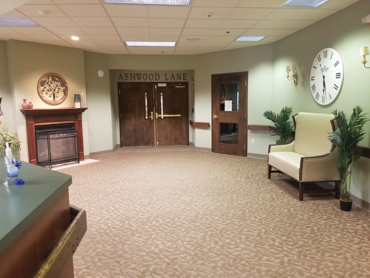 A spacious lobby with a carpeted floor, featuring seating and decor.