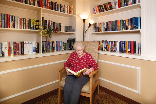 An elderly person enjoying a quiet moment with a book in a cozy reading nook.