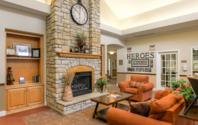A cozy living room with a stone fireplace and warm-toned furniture.