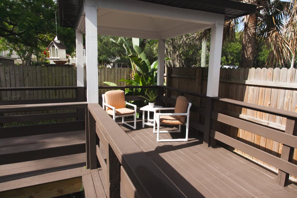Outdoor patio with chairs and a small table on a wooden deck.