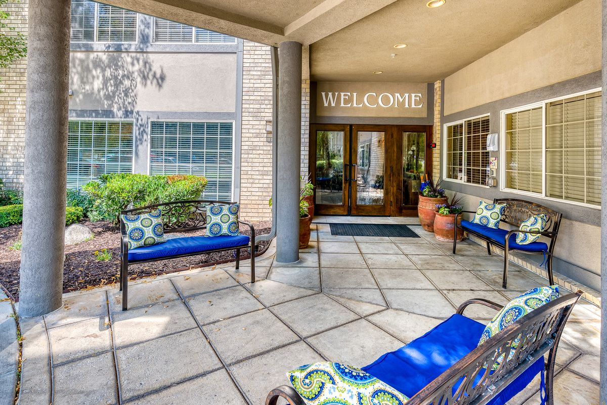 A welcoming entrance with outdoor seating and a 'Welcome' sign above the doors.