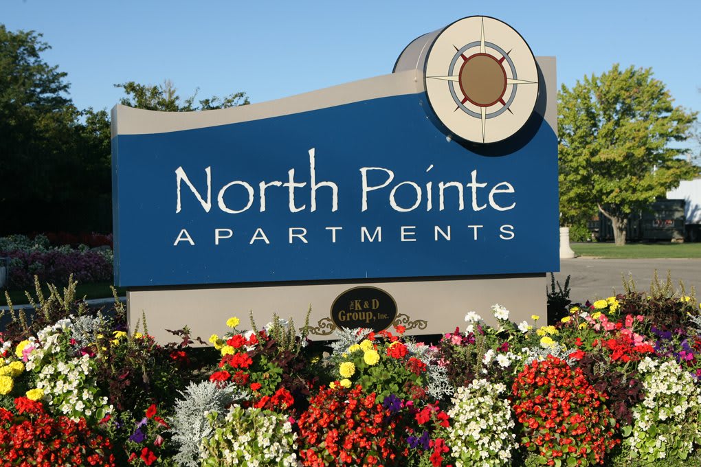 Entrance sign for North Pointe Apartments surrounded by colorful flowers.
