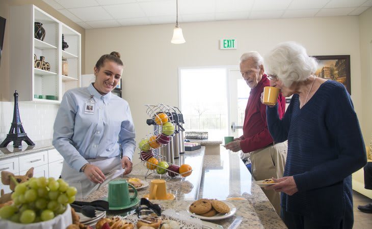 People enjoying coffee and snacks in a cafeteria setting.