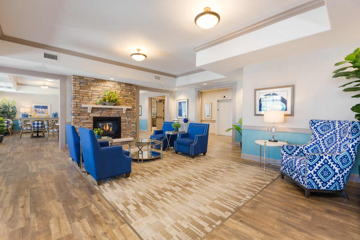 A modern living room with blue chairs and a fireplace, showcasing elegant interior design.