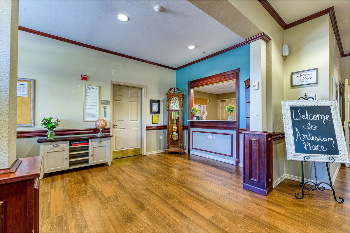 Reception area with a wooden floor and decorative elements.