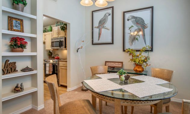 A cozy dining area with bird-themed artwork and a view into the kitchen.