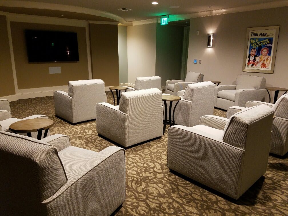 A comfortable lounge area with several armchairs facing a television.