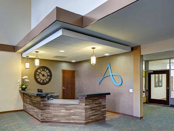 A modern reception area with a stylish desk and pendant lighting.