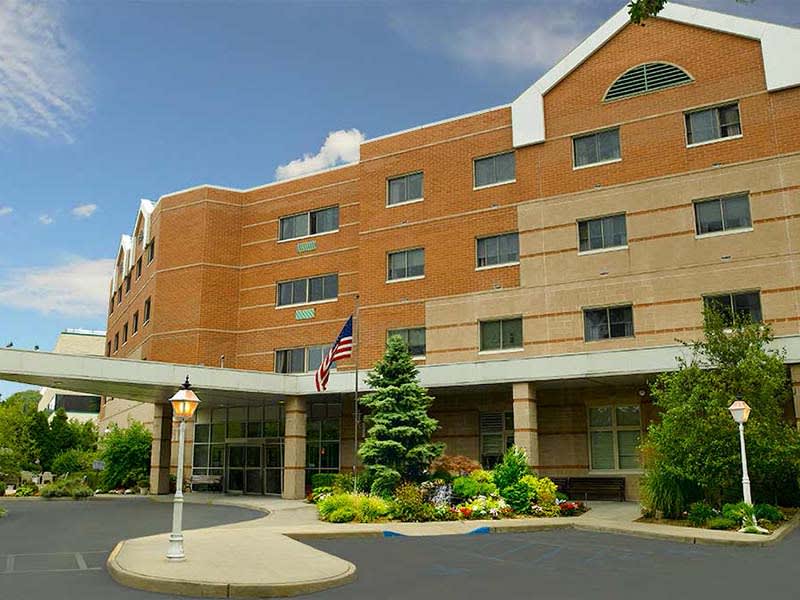 Exterior view of a hospital building with an entrance and landscaping.