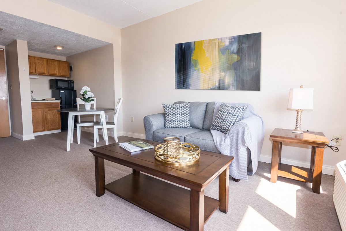 A cozy living room with stylish decor, featuring a sofa, coffee table, and abstract artwork.