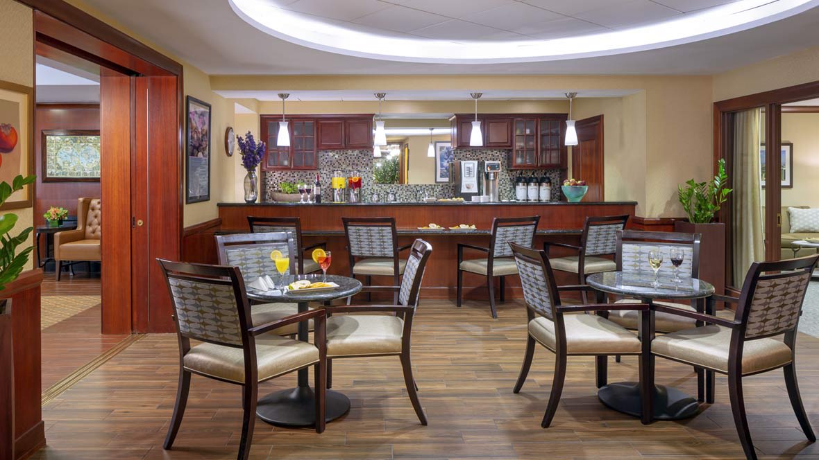 A cozy cafe interior with several tables and chairs, featuring modern decor and warm lighting.