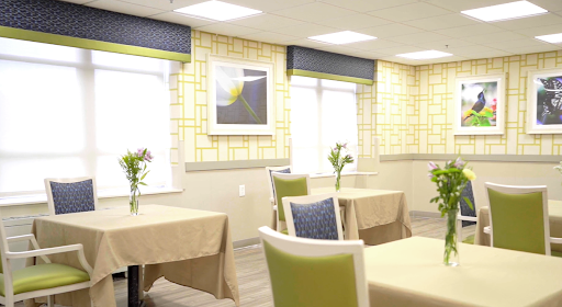 A well-lit dining area featuring elegant tables and chairs, complemented by floral arrangements and wall art.